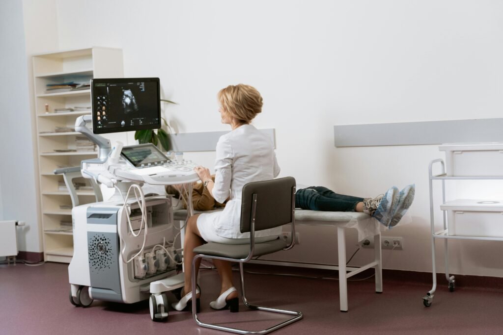  doctor conducting a sonogram to woman laying down